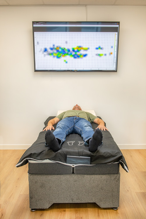 A client getting a body pressure scan in their sleep position